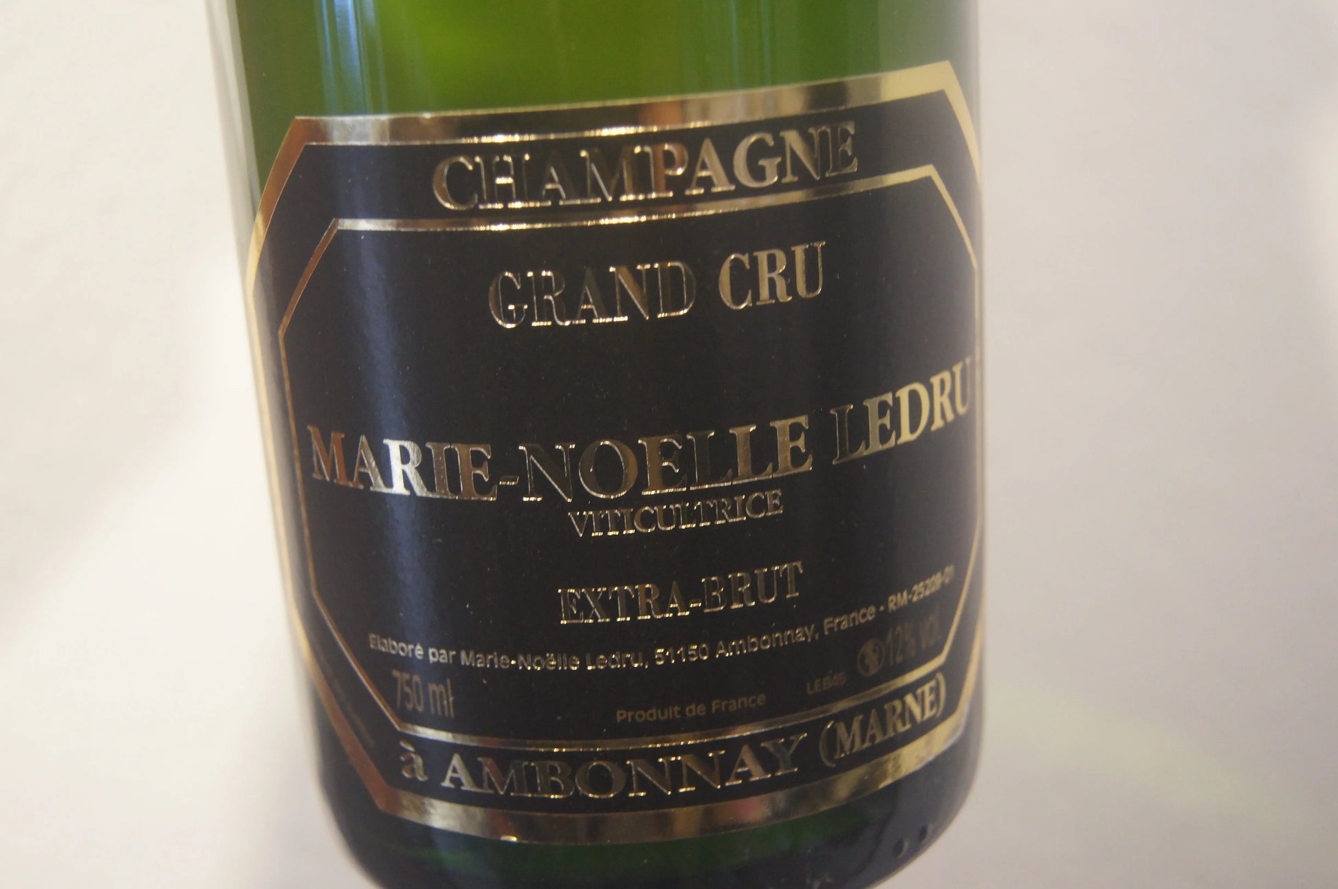 Ein Glas Marie-Noelle Ledru Grand Cru Extra Brut mit Blick auf die Weinberge von Champagne.