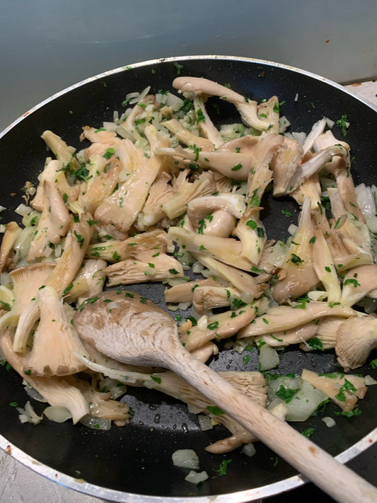 Champagnerglas neben gebratenen Pilzen – zeigt, wie Umami und Meunier-Champagner harmonisch zusammenwirken.